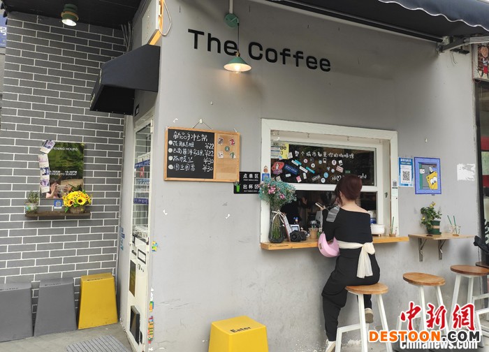 来自台湾的吴家成在湖南长沙开的第一家街角咖啡店，凭借其“颜值”和亲民价格，吸引着不少市民和游客前来“打卡”。年逾五旬的吴家成是湖南女婿，常年在越南经商，主要从事咖啡种植。2020年6月，他与妻儿从越南回湖南探亲后，因疫情等原因留在了湖南发展。图为4月10日，顾客在吴家成开的咖啡店里消费。 中新社记者 邓霞 摄