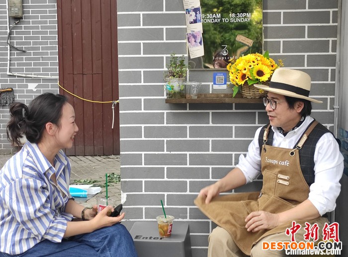 图为4月10日，吴家成与妻子在咖啡店外聊天。 中新社记者 邓霞 摄